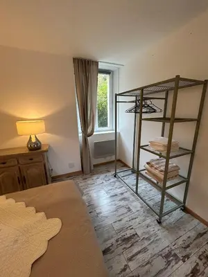 a room with a bed and a shelf with towels at Le laurier, confort et calme en Provence in Noves