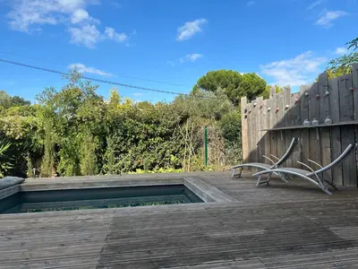 a wooden deck with a bench and a fence at Le laurier, confort et calme en Provence in Noves
