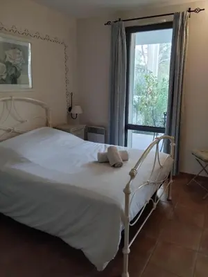 a bedroom with a white bed and a window at Golf de saumane in Saumane-de-Vaucluse