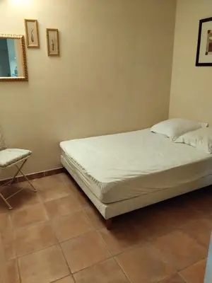 a bedroom with a bed and a chair in it at Golf de saumane in Saumane-de-Vaucluse