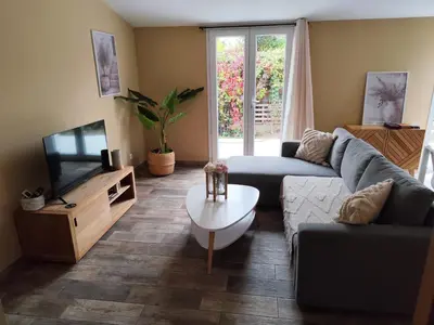 a living room with a couch and a tv at Petite maison de charme in LʼIsle-sur-la-Sorgue