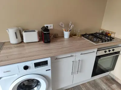 a kitchen with a washing machine and a stove at Petite maison de charme in LʼIsle-sur-la-Sorgue