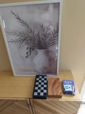 a picture of a vase on a table with a clock at Petite maison de charme in LʼIsle-sur-la-Sorgue