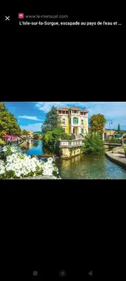 a picture of a river with a building at Petite maison de charme in LʼIsle-sur-la-Sorgue
