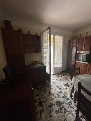 a room with a kitchen with a table and a refrigerator at Maison Provençale au centre du village in Mollégès