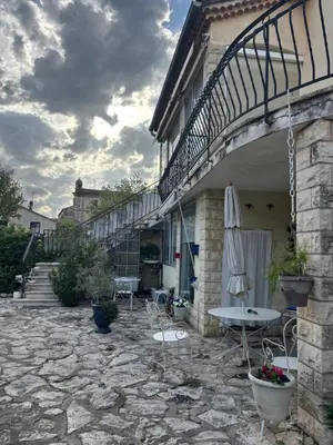 a patio with chairs and an umbrella on a building at Maison Provençale au centre du village in Mollégès