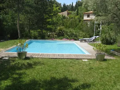 a swimming pool in a yard with two potted plants at Studio indépendant dans propriété campagne Aixoise terrasse et piscine période estivale in Aix-en-Provence