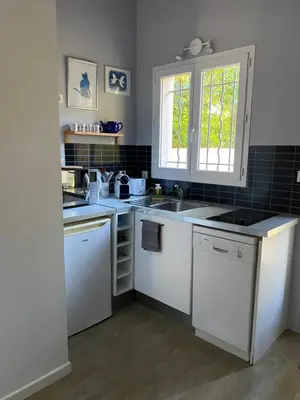 a kitchen with white counters and a sink and a window at Studio indépendant dans propriété campagne Aixoise terrasse et piscine période estivale in Aix-en-Provence