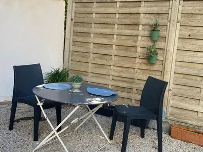 a table and two chairs in front of a fence at Studio indépendant dans propriété campagne Aixoise terrasse et piscine période estivale in Aix-en-Provence