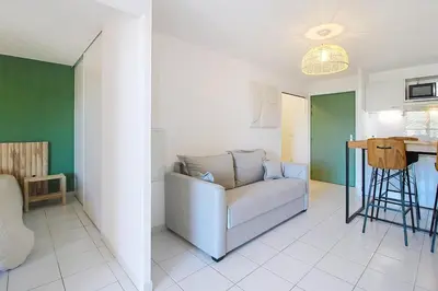 a living room with a couch and a kitchen at Le Nid du Pradon in Cavaillon