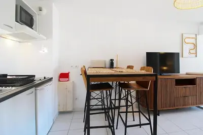 a kitchen with a table with chairs and a television at Le Nid du Pradon in Cavaillon