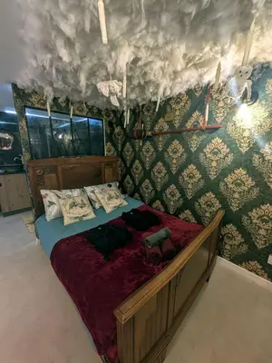 a bedroom with a bed in a room with wallpaper at Le Repaire du Sorcier in Caumont-sur-Durance