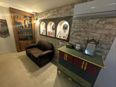 a living room with a chair and a dresser and a mirror at Le Repaire du Sorcier in Caumont-sur-Durance