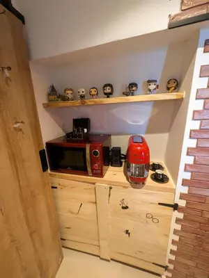 a small kitchen with a microwave on a wooden cabinet at Le Repaire du Sorcier in Caumont-sur-Durance