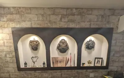 a wall with a shelf with masks on it at Le Repaire du Sorcier in Caumont-sur-Durance