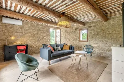 a living room with a couch and a chair at La Bergerie des Sorgues in LʼIsle-sur-la-Sorgue