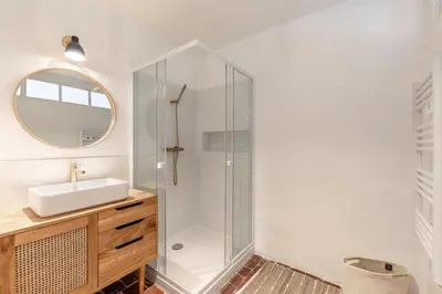 a bathroom with a shower with a sink and a mirror at La Bergerie des Sorgues in LʼIsle-sur-la-Sorgue