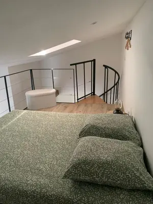 a bedroom with a bed with a green comforter at Studio cosy à la campagne in Montjustin