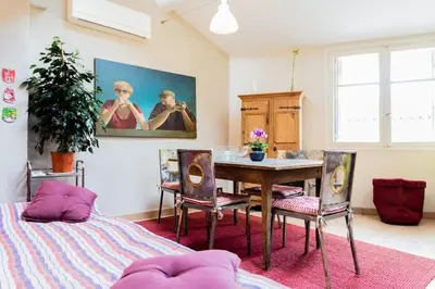 a dining room with a table and chairs and a painting at Urban loft with terrace downtown in Aix-en-Provence