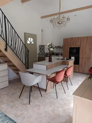 a kitchen with a table and chairs and a staircase at petite Villa in Manosque