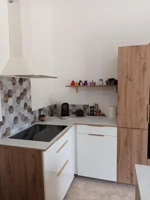 a kitchen with white cabinets and a refrigerator at petite Villa in Manosque