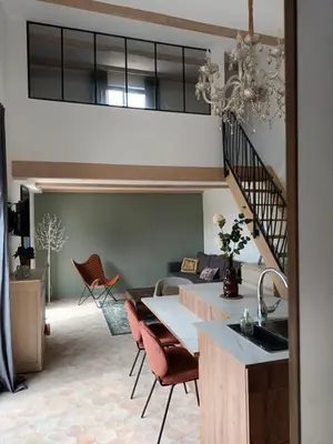 a living room with a staircase and a table and chairs at petite Villa in Manosque