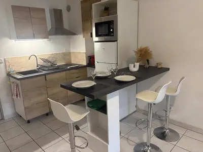 a kitchen with a island with chairs and a counter top at Magnifique T2 Aix-en-Provence in Aix-en-Provence