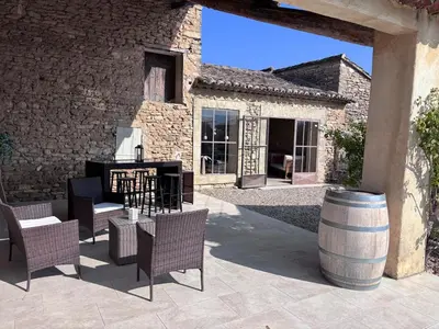 a patio with chairs and a grill and a barrel at Mas Provençal avec piscine à Gordes in Gordes