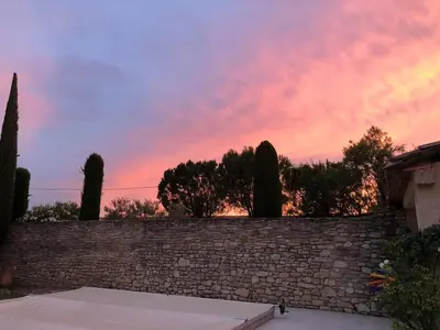 a sunset over a brick wall with trees and trees at Mas Provençal avec piscine à Gordes in Gordes
