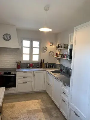 a kitchen with white cabinets and a stove top oven at Mas Provençal avec piscine à Gordes in Gordes
