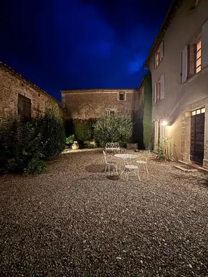 a table and chairs in a courtyard at night at Mas Provençal avec piscine à Gordes in Gordes