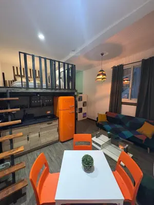 a living room with a table and orange chairs at Le Cocoon Provençal - à deux pas de la mairie tout inclus in Aix-en-Provence