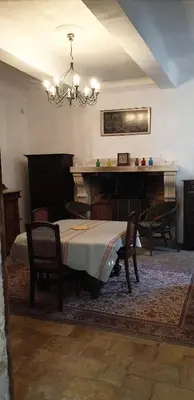 a dining room with a table and a piano at Magnifique demeure de caractère au cœur de Lacoste in Lacoste