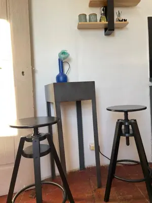 two tables and two stools in a room at L'escalier gaucher in Lambesc