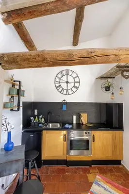 a kitchen with a sink and a clock on the wall at L'escalier gaucher in Lambesc