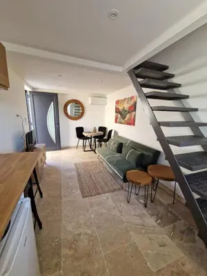 a living room with a green couch and a staircase at Duplex Design - Clim - Parking privé - Wifi - by CommeChezSoi in Vedène