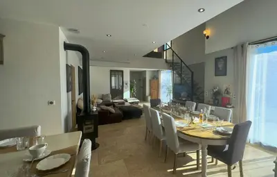 a dining room and living room with a table and chairs at Modern Villa With Views Of Gordes in Gordes