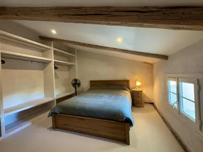 a bedroom with a large bed and a window at Charmant mas perché en Provence in Saumane-de-Vaucluse