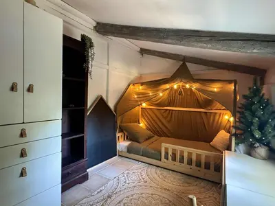a bedroom with a canopy bed with a christmas tree at Charmant mas perché en Provence in Saumane-de-Vaucluse