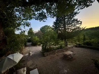 a view of a garden with a table and chairs at Charmant mas perché en Provence in Saumane-de-Vaucluse
