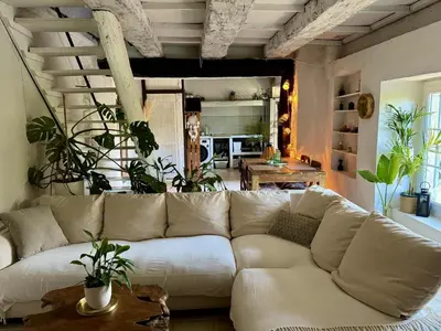 a white couch in a living room with plants at Charmant mas perché en Provence in Saumane-de-Vaucluse