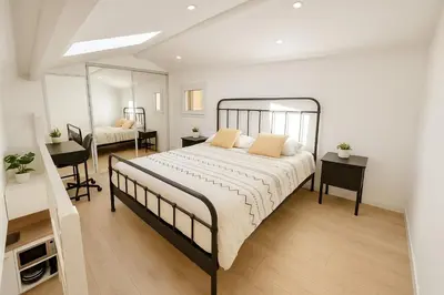 a bedroom with a large bed and a mirror at Le Nily Provence, T2 cosy rénové avec Clim, Extérieur et Parking in Sainte-Tulle