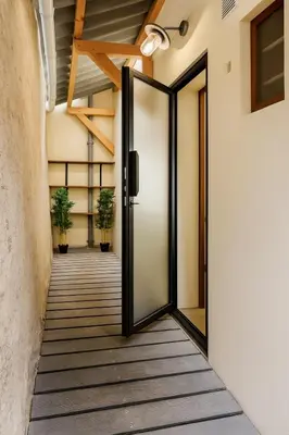 an open door to a hallway with potted plants at Le Nily Provence, T2 cosy rénové avec Clim, Extérieur et Parking in Sainte-Tulle