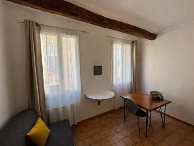 a living room with a table and two windows at Casa Centrale in Aix-en-Provence