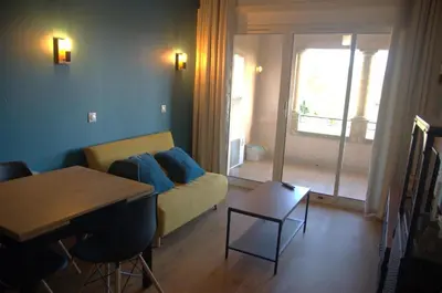 a living room with a couch and a table at Appartement Pont Royal vu lac in Mallemort