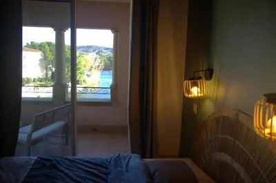 a bedroom with a bed and a view of a balcony at Appartement Pont Royal vu lac in Mallemort