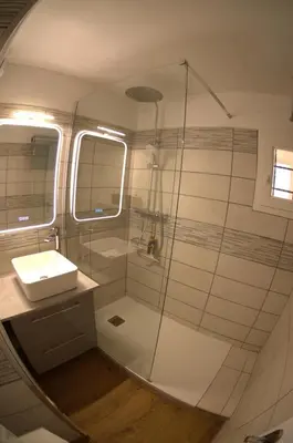 a bathroom with a glass shower and a sink at Appartement Pont Royal vu lac in Mallemort