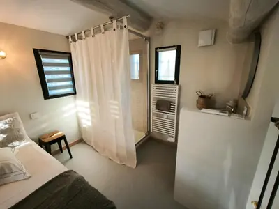 a bedroom with a bed and a window at Le Mazet de Christol in Eygalières