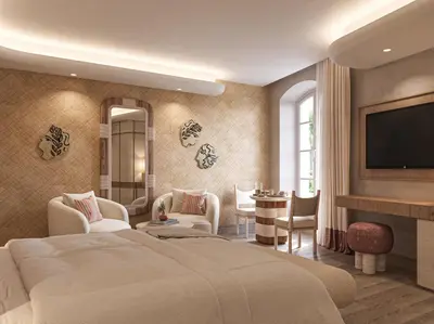a living room with a tv on a wall at Hôtel de La Fontaine in Lourmarin