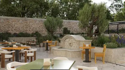 a restaurant with tables and chairs in a courtyard at Hôtel de La Fontaine in Lourmarin